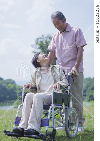 車椅子で散歩をする夫婦 11623256