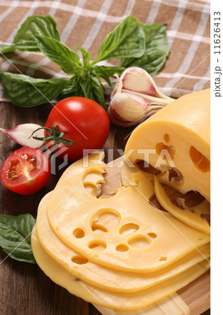 Cheese on a cutting board, basil, tomato 11626413