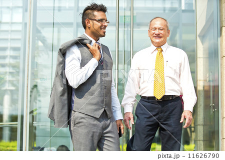 Senior businessman and young businessman outside glass building Senior businessman and young businessman outside glass building 11626790