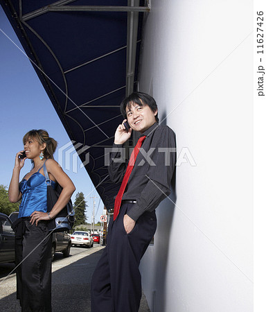 Asian couple talking on cell phones 11627426