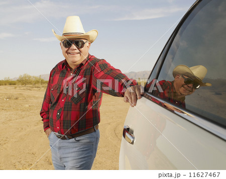 Senior Mixed Race man leaning on car 11627467