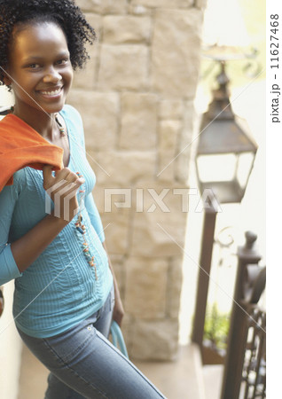 Young African woman with jacket over shoulder smiling 11627468