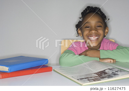 African girl at table with school books 11627475