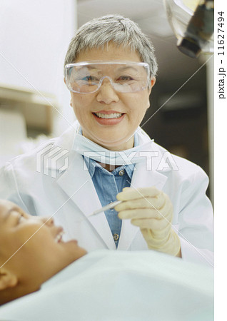 Senior Asian female dentist working on African boy Senior Asian female dentist working on African boy 11627494