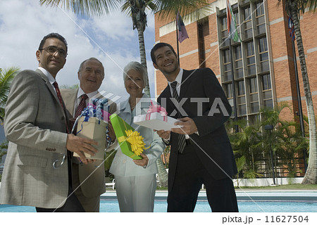Hispanic businesspeople holding gifts 11627504