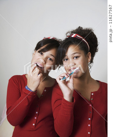 African twin sisters brushing teeth African twin sisters brushing teeth 11627567