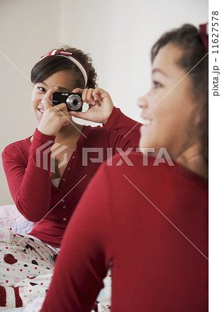 African twin sisters taking photograph 11627578
