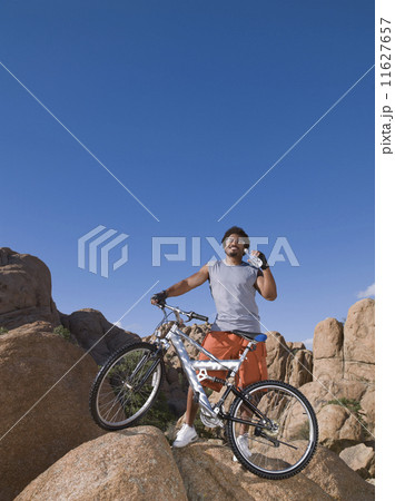 African man with mountain bike on rocks 11627657