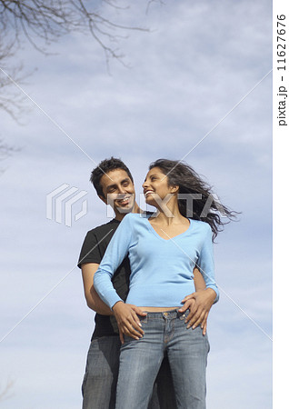 Low angle view of couple hugging 11627676