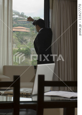 Hispanic businessman looking out window 11627770