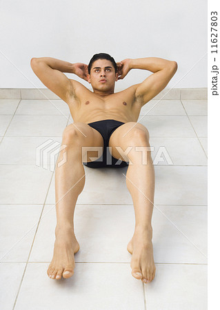 Bare-chested Hispanic man doing sit-ups 11627803