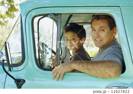 Hispanic father and son sitting in truck 11627822