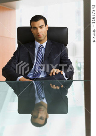 Hispanic businessman sitting at desk Hispanic businessman sitting at desk 11627843