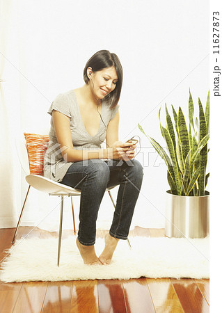 Asian woman listening to mp3 player Asian woman listening to mp3 player 11627873