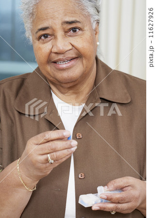 Senior African American woman holding medication 11627926