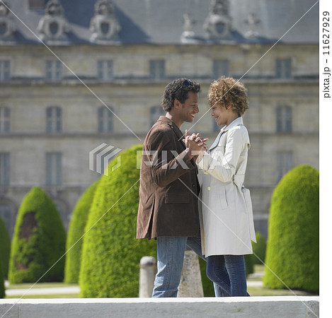 African couple smiling at each other in front of historical building 11627929