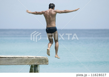 Hispanic man jumping off dock 11628027