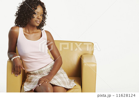 Studio shot of African woman in armchair Studio shot of African woman in armchair 11628124