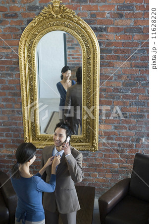 Asian woman adjusting husband's necktie 11628220