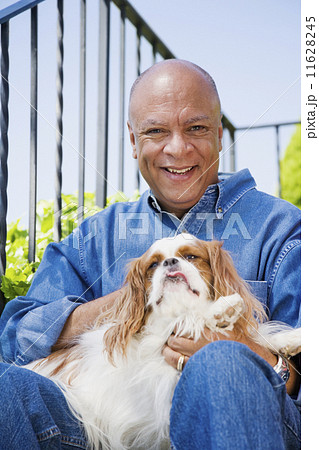Senior African American man hugging dog 11628245