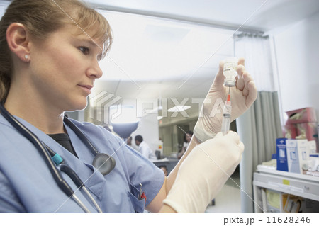 Close up of female nurse filling syringe 11628246