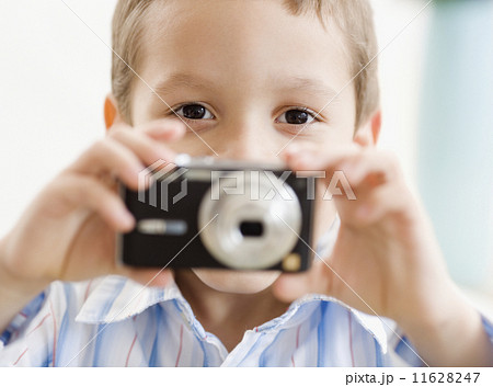 Hispanic boy taking photograph 11628247