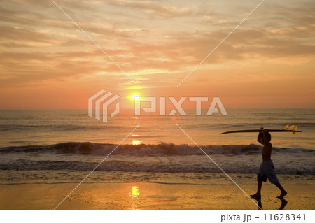 Asian boy carrying surfboard at beach 11628341