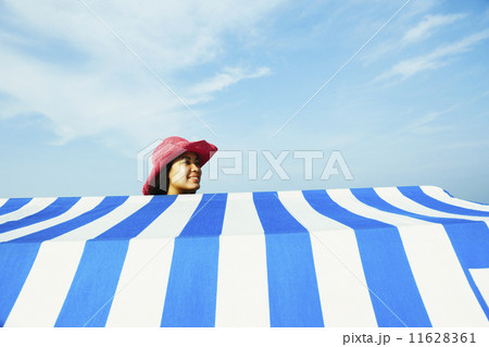 Hispanic woman standing behind beach sun shade 11628361
