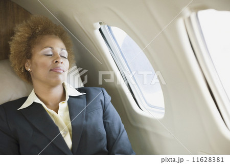 African American businesswoman sleeping on airplane 11628381