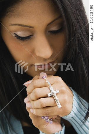 Hispanic woman holding rosary beads 11628499