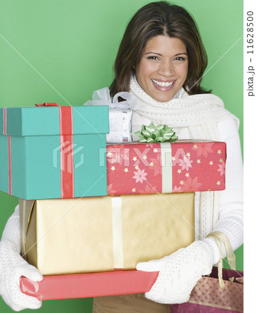 Portrait of woman holding stack of gifts 11628500