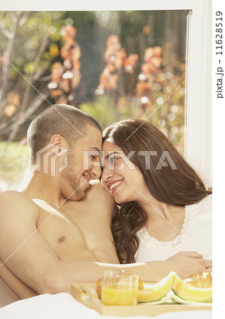 Hispanic couple having breakfast in bed  11628519