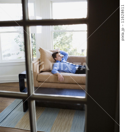 Hispanic businessman laying on sofa Hispanic businessman laying on sofa 11628611