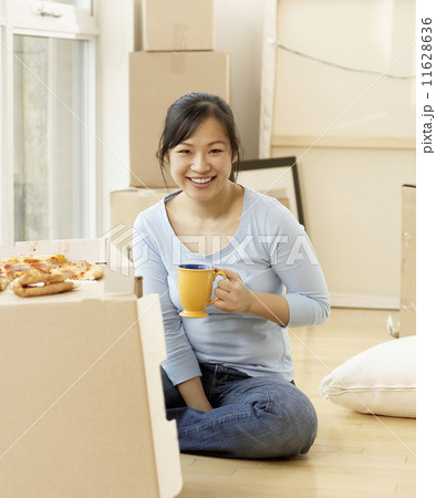 Asian woman surrounded by moving boxes Asian woman surrounded by moving boxes 11628636