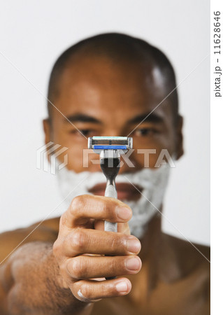 Asian man holding up razor Asian man holding up razor 11628646