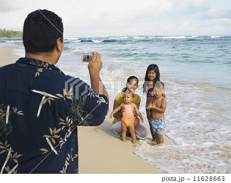 Pacific Islander father taking photograph of family 11628663