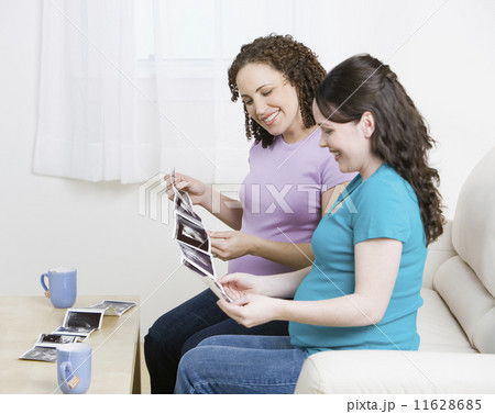 Multi-ethnic pregnant women looking at ultrasounds 11628685