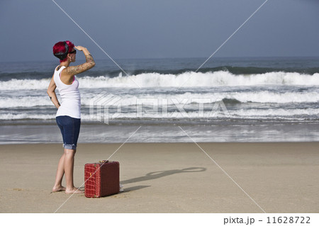 Tattooed Hispanic woman on beach 11628722