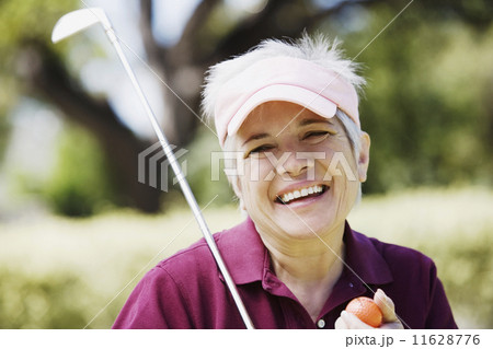 Middle-aged woman with golf club and golf ball 11628776