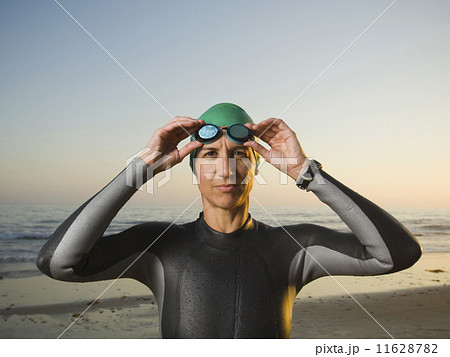 Hispanic woman wearing wetsuit and goggles 11628782
