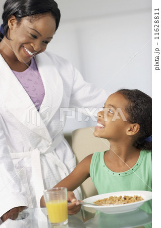 African American mother and daughter smiling at each other 11628811