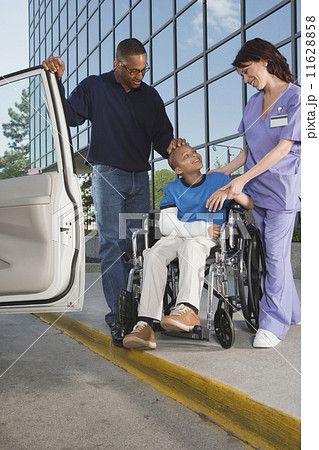 African boy in wheelchair leaving hospital with father African boy in wheelchair leaving hospital with father 11628858