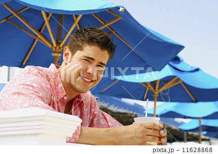 Young man holding drink outdoors 11628868