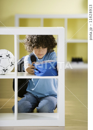 Hispanic boy putting away lunch box Hispanic boy putting away lunch box 11628913