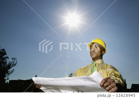 African American businessman holding blueprints African American businessman holding blueprints 11628945