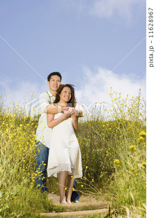 Asian couple hugging in field Asian couple hugging in field 11628967