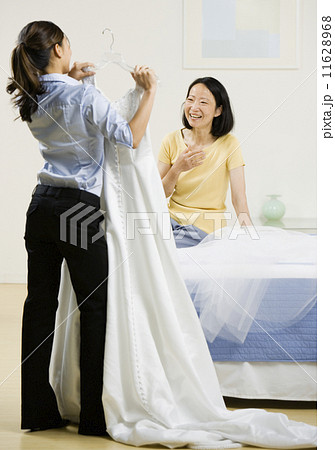 Asian woman showing wedding dress to mother Asian woman showing wedding dress to mother 11628968