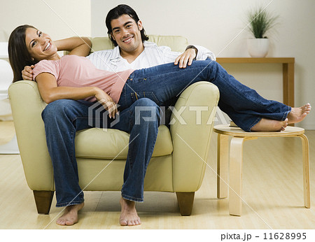 Multi-ethnic couple sitting on chair Multi-ethnic couple sitting on chair 11628995