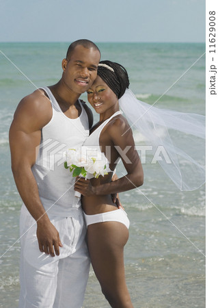 African bride and groom hugging at beach 11629008