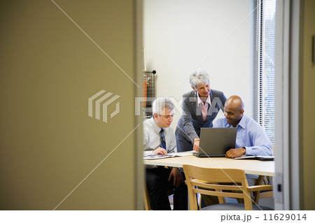 Multi-ethnic businesspeople looking at laptop 11629014